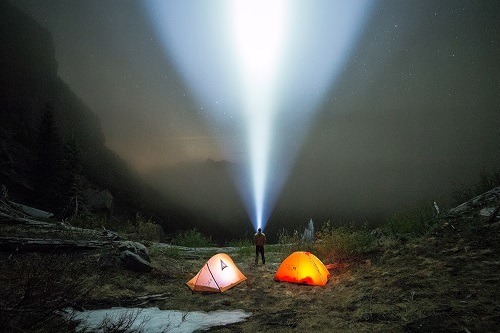 Man Pointing Flashlight in the Sky by Night